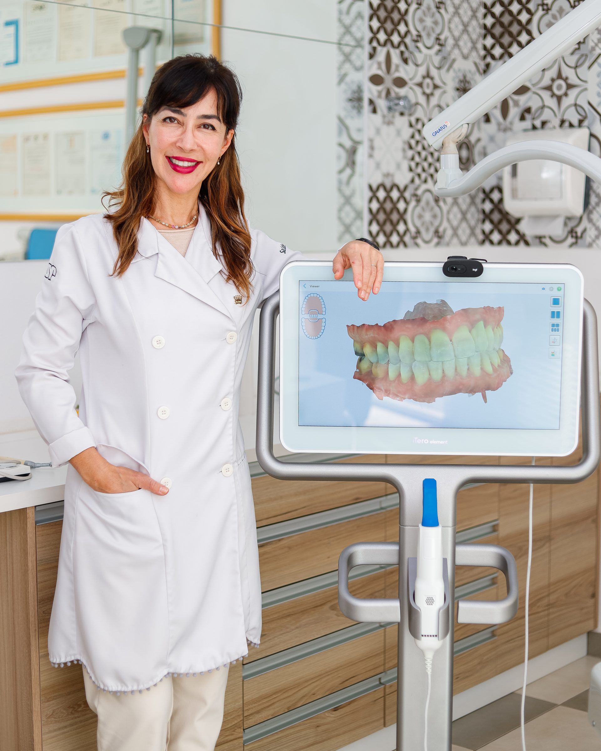 Dra. Fábia ao lado da tela do scanner, que mostra os dentes em 3D para o planejamento