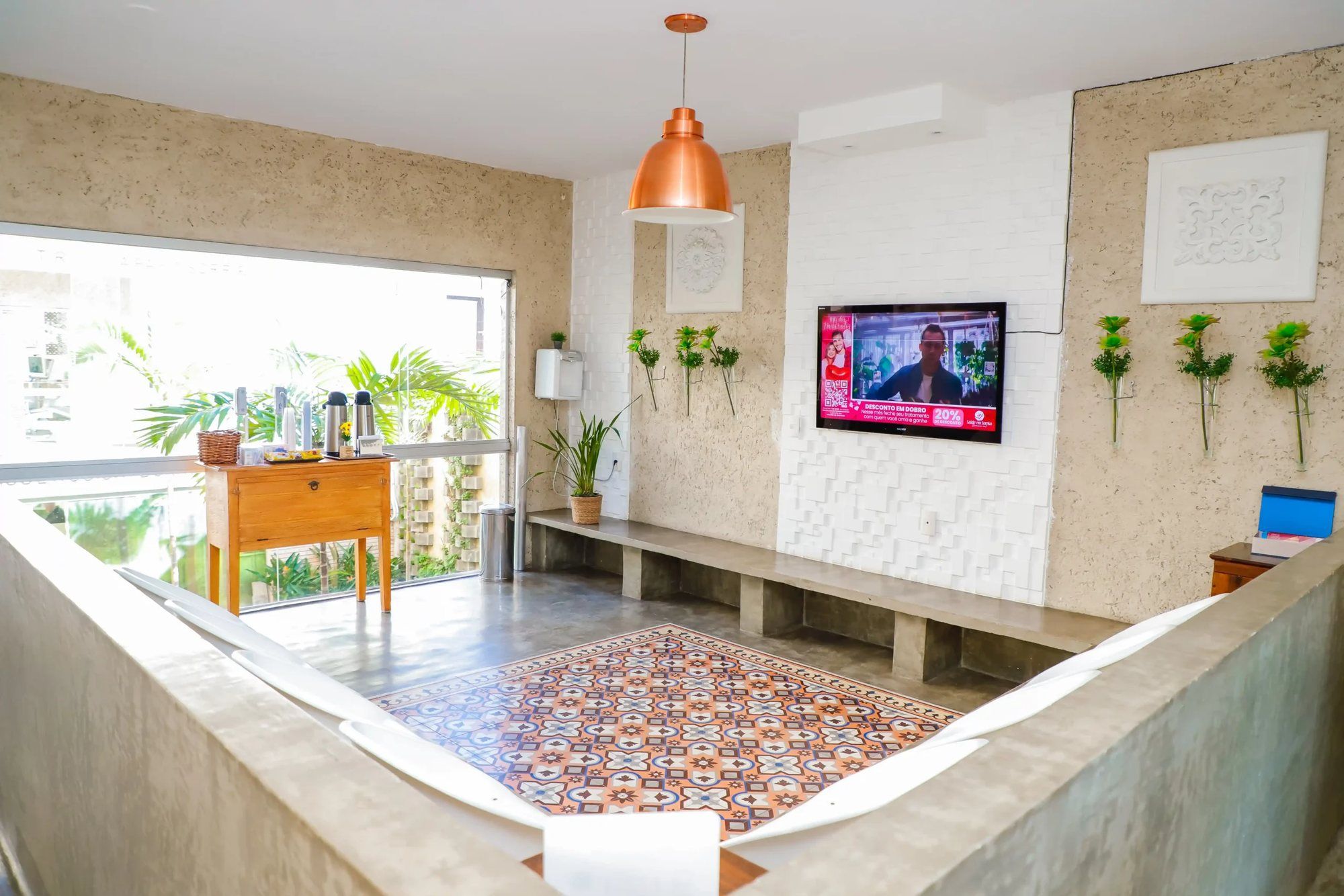 Sala de espera com bancos de concreto e tapete de ladrilho hidráulico